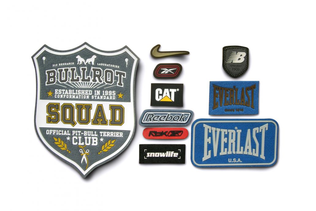 Various badges and patches on a white background.
