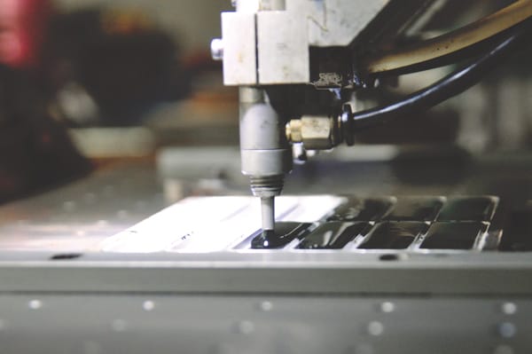 A machine processing a piece of metal.